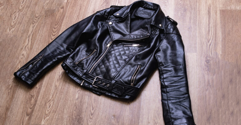 Black leather jacket on a wooden background Black leather jacket on a wooden background close up