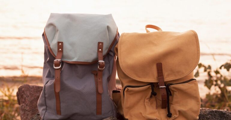 couple-backpacks-rocks-sunset couple-backpacks-rocks-sunset