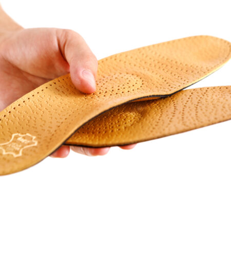 orthopedic insole in the doctor's hands on a white background. treatment of flat feet.